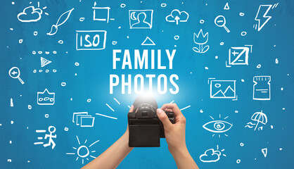 Fototapeta na wymiar Hand taking picture with digital camera and FAMILY PHOTOS inscription, camera settings concept