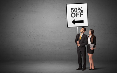 business person holding a traffic sign with 50% OFF inscription, new idea concept