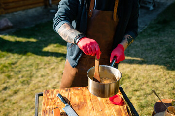 The cook mixes food in a saucepan. Concept of the correct cooking of meat. The chef prepares, fries...