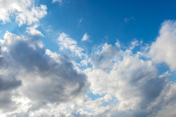 Illuminated by the sun white clouds in the blue sky