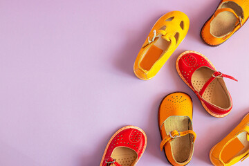 Stylish new yellow children's shoes on a colored background with copyspace