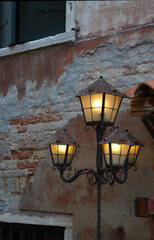 
characteristic lamppost with lights on in front of a house