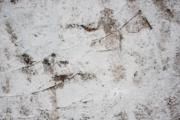 Grey concrete wall covered with cracks