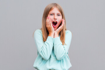 Surprised happy beautiful woman looking sideways in excitement. Isolated on gray background