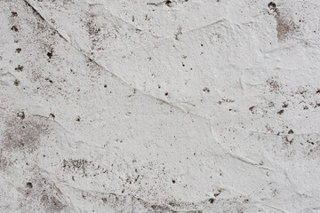 Grey concrete wall covered with cracks