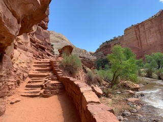 Sandstone steps next to flowing river through desert canyon, Capital Reef National Park, Utah