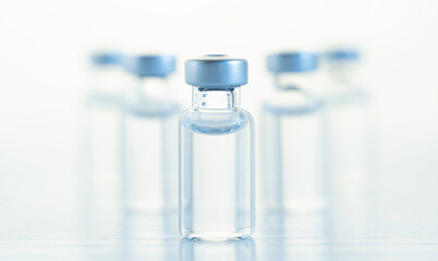 Many transparent vials with vaccine for covid-19 coronavirus, flu, infectious diseases. Injection after clinical trials for vaccination of human, child, adult, senior. Medicine, drug concept