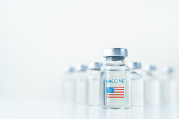 Obraz premium Transparent vials with USA flag. Vaccine for covid-19 coronavirus, flu, infectious diseases. Injection after clinical trials for vaccination of human, child, adult, senior. Medicine, drug concept