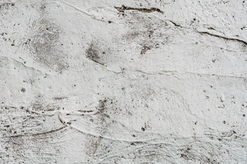 Grey concrete wall covered with cracks