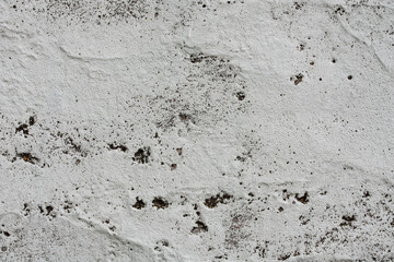 Grey concrete wall covered with cracks