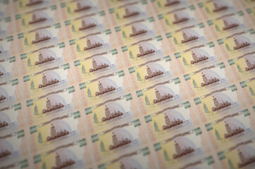 100 Ukrainian hryvnias bills printed in illegal money production conveyor. Collage of many fake...