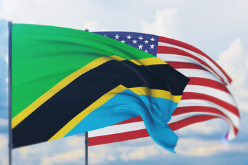Waving American flag and flag of Tanzania. Closeup view, 3D illustration.