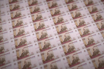 100 russian rubles bills printed in illegal money production conveyor. Collage of many fake bills....
