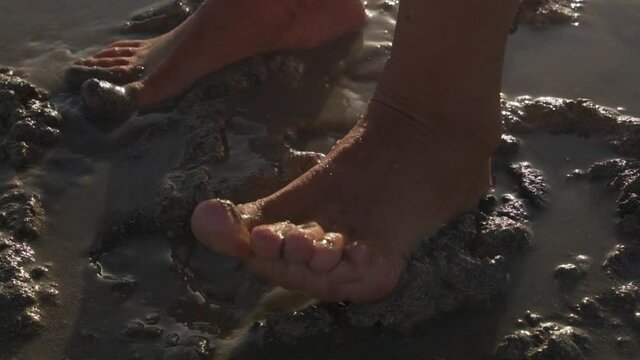 close up of handsome female feet dancing in mud slow motion