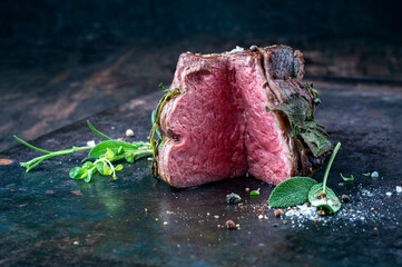 Traditional barbecue dry aged wagyu chateaubriand beef steak offerd spice and herbs as close-up on a rustic metal board