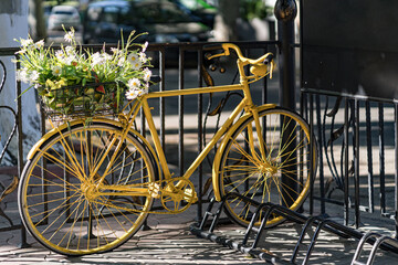 Fototapeta na wymiar Retro yellow bicycle on roadside with city fence brick wall background