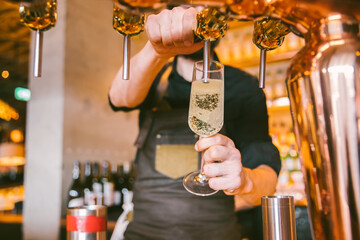 barman pouring a glass of prosecco on tap