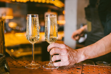 barman putting two glasses of prosecco on the table