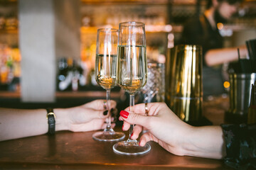 2 women holding prosecco glasses in a bar - 376123385