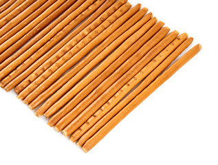 Creative layout made of crackers sticks on the white background. Food concept. Edible snack dry sticks with salt on white background. Straws, sticks crackers.