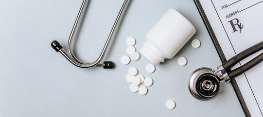 White pills, stethoscope, prescription on the doctor's table. Medicine concept. Research on prescribing the dose of medicinal products. Health care or illness. Tablet or drug in hospital or pharmacy.