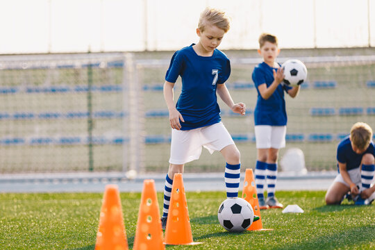 Happy School Kids Practice Soccer on the Training Field