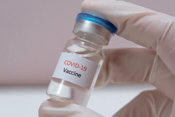 Vaccine COVID-19 (Coronavirus) glass bottle in medical doctor hand