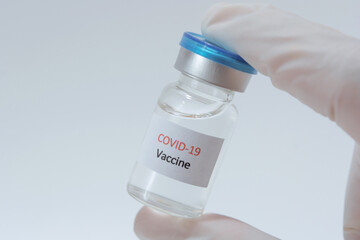 Vaccine COVID-19 (Coronavirus) glass bottle in medical doctor hand