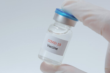 Vaccine COVID-19 (Coronavirus) glass bottle in medical doctor hand