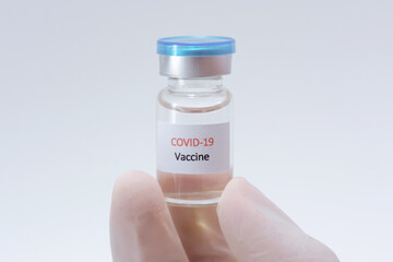 Vaccine COVID-19 (Coronavirus) glass bottle in medical doctor hand