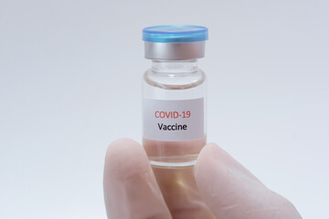 Vaccine COVID-19 (Coronavirus) glass bottle in medical doctor hand