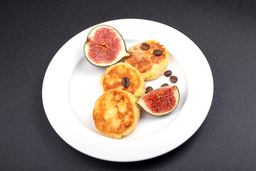 Figs on a white plate with cheese cakes. Ripe sweet figs. Healthy Mediterranean figs. Food concept.
