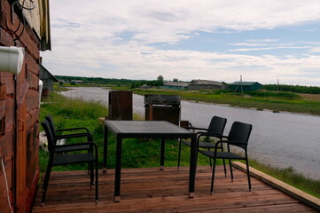 Seating area, table and chairs on the patio, near the river