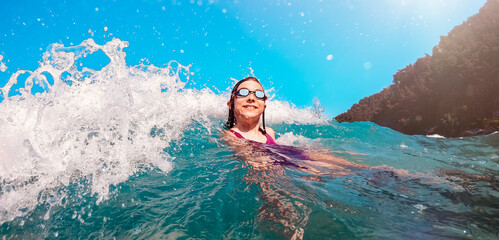Happy little girl swimming in the sea