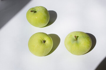 Three green garden apples on white  background vitamin healthy seasonal food concept  