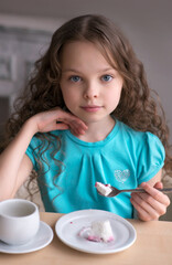 cute little girl sitting by dinner table and eating