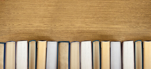 Old books on a wooden shelf with blurred backgrund