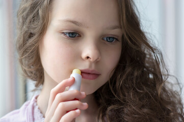 Portrait of beautiful little girl applying lipbalm.