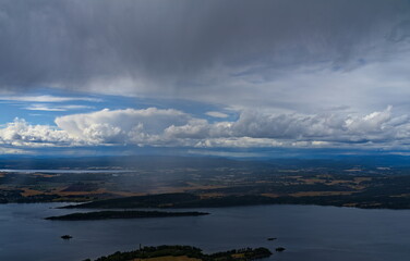 Panoramic view of a rural landscape with heavy dark rain storm clouds moving in.