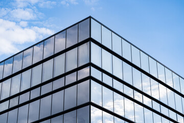 Fototapeta na wymiar Modern Glass Building Architecture with blue sky and clouds