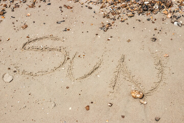 The word sun written in sand on a beach