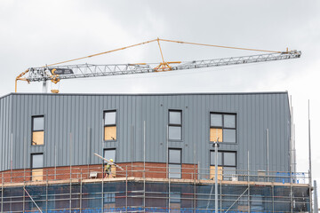 Obraz premium A tower block under construction with builders working on scaffolding