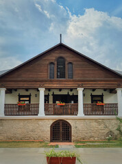 Obraz premium The Museum house facade at Manuc Bei mansion, architectural, culture and historic complex of Hincesti city, Moldova. Old, traditional moldavian rural home with porch on pillars, stone and wood details