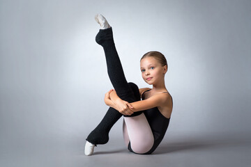 A little adorable young ballerina poses in studio