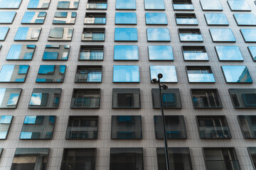 Upwards angle look up shot of big modern building with sky reflection on the windows