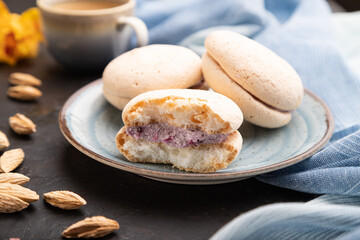 Meringues cakes with cup of coffee on a black concrete background. Side view, selective focus.