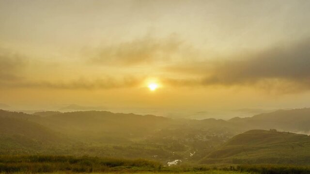 Beautiful golden sunrise with fast rolling clouds drifting over the village. Taken at RANAU, SABAH , BORNEO. time lapse motion tilt up