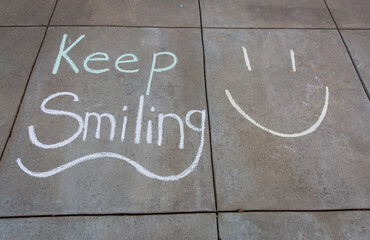 Keep smiling written with sidewalk chalk