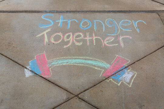 Stronger together written with sidewalk chalk