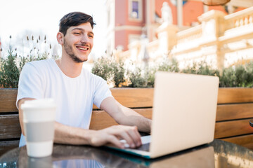 Young man using his laptop in a coffee shop.